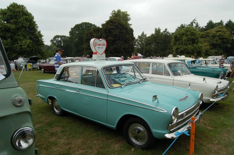 the two old cars are parked on the grass