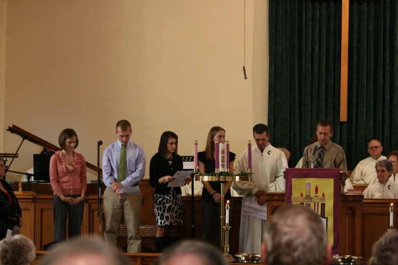 a bunch of people standing behind a podium in a church