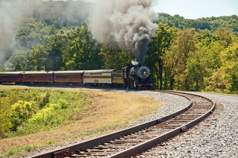 a train travels on the tracks with smoke billowing out