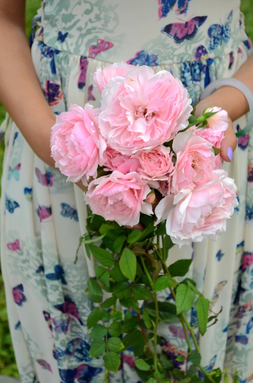 a pink flower bunch in a woman's hand