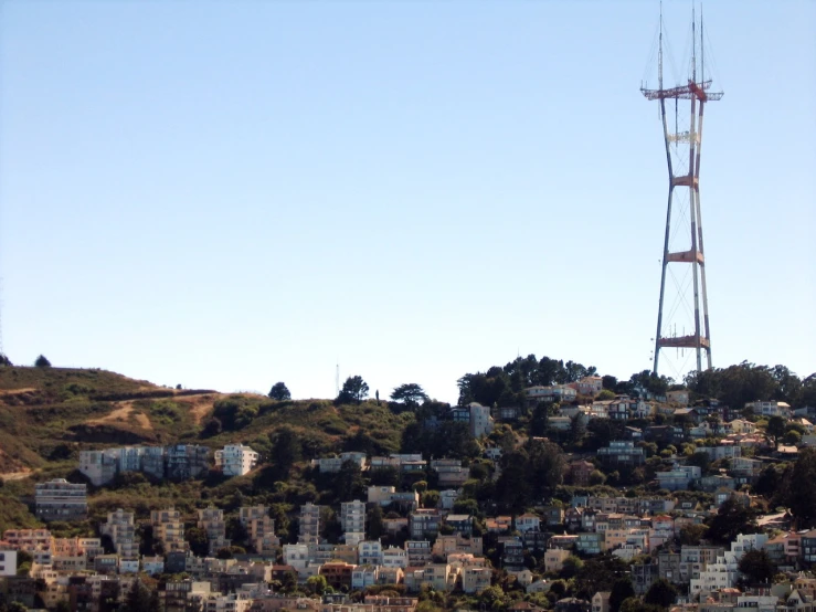 a high tower with antennas next to a city