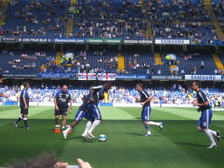 a group of men in blue jerseys playing soccer
