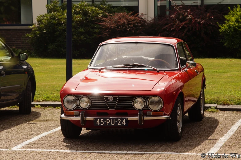 an old red car parked in the lot