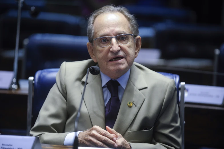 a man in glasses wearing a jacket and tie