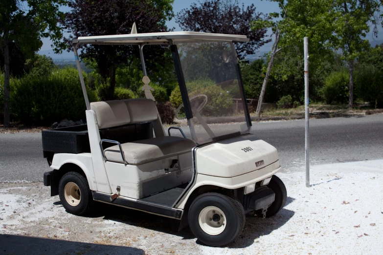 the large white golf cart is parked on the street