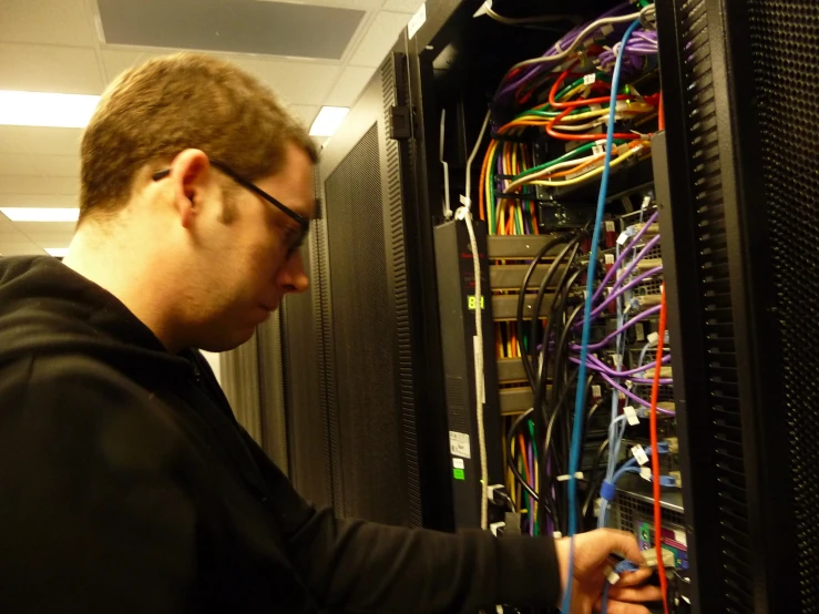 a man looking at a server in a room