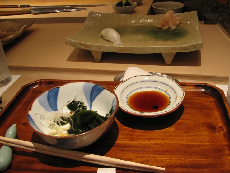 bowls of soup and chopsticks on a tray