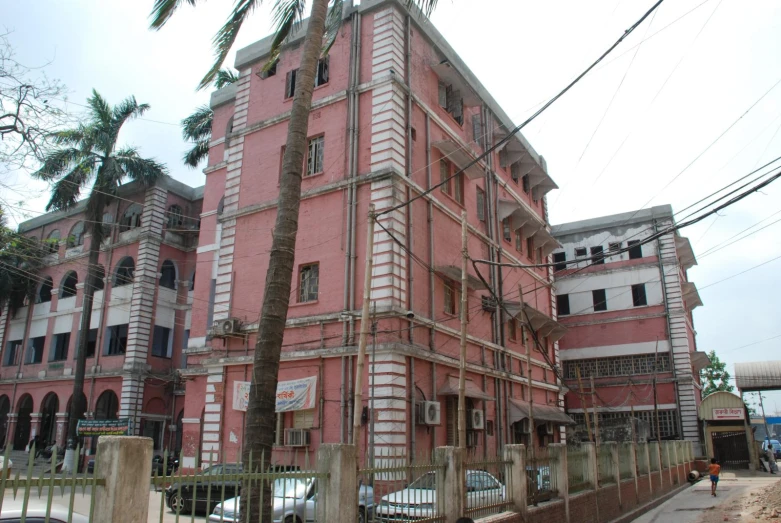 a pink building with a fence next to it