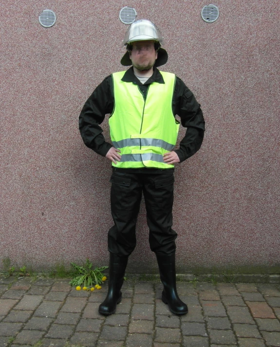 a construction worker standing in front of a wall with a helmet on