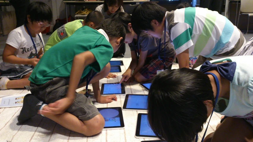 several children are learning on different ipads