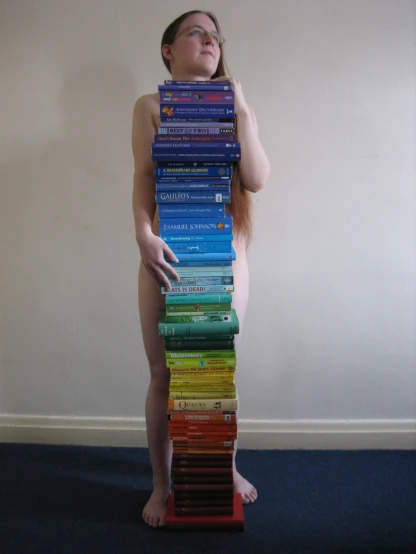 there is a girl that has stacked books on her back