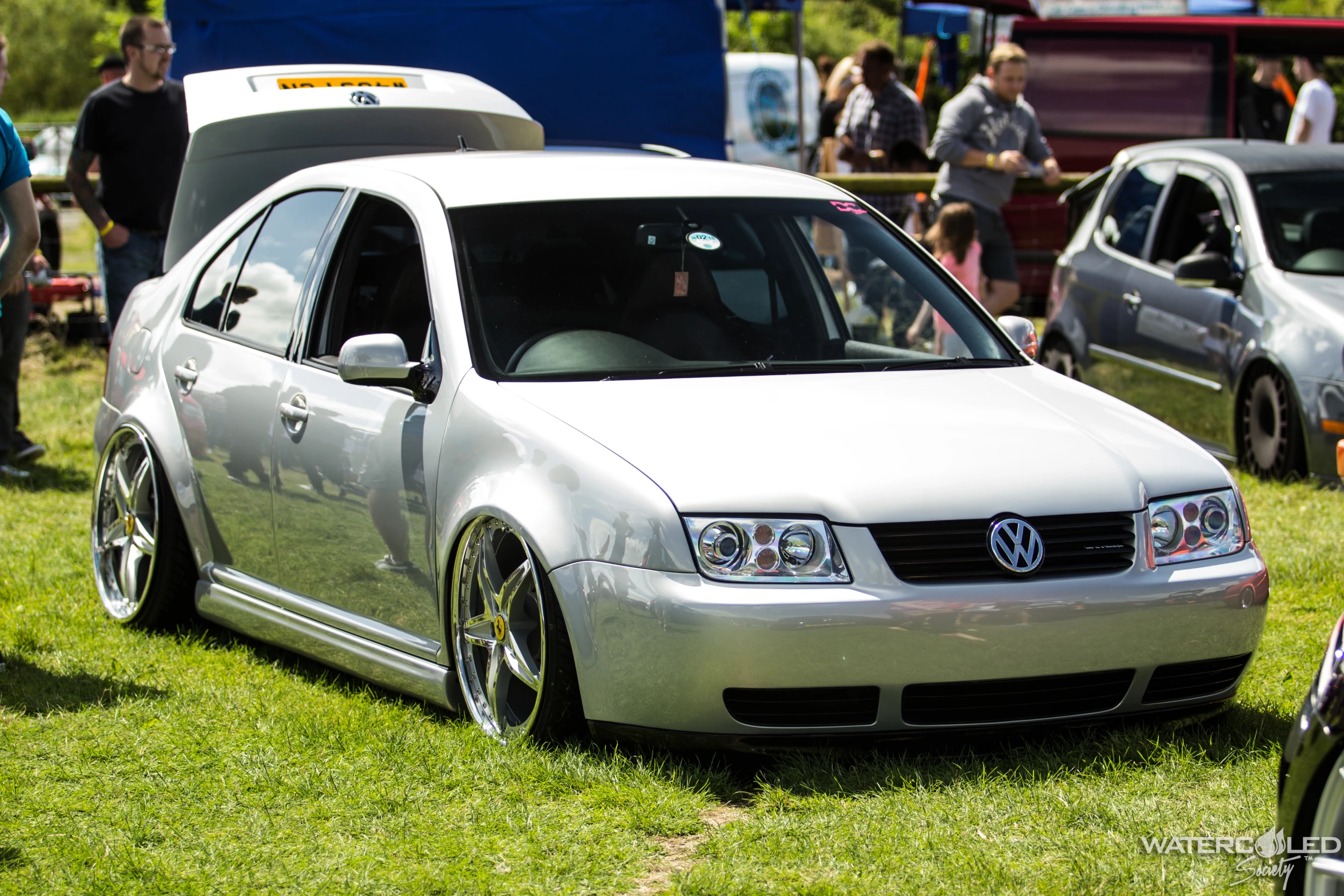 a silver wagon is parked in the grass