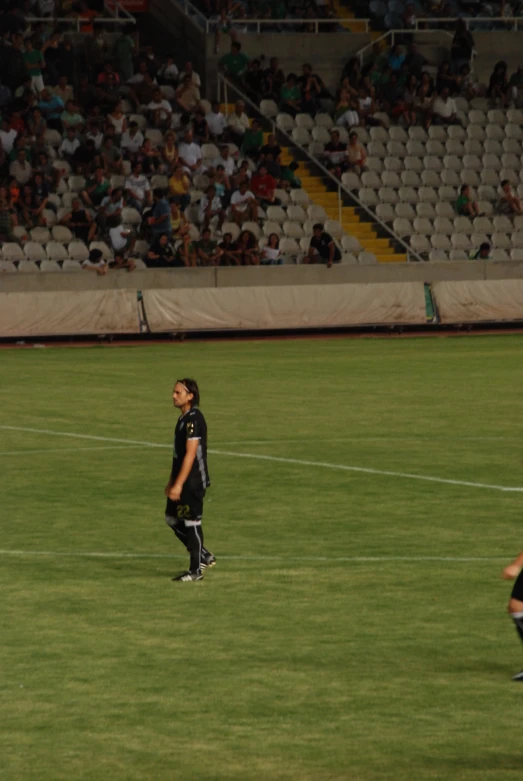 a soccer player standing on a field with a ball