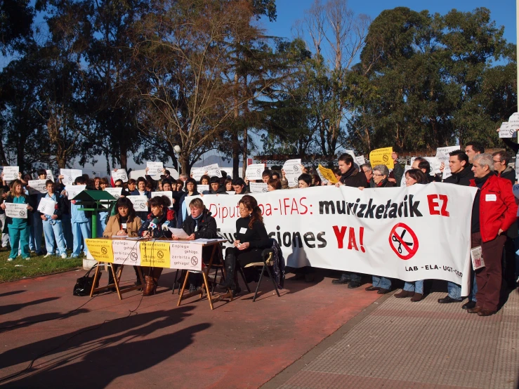 many people holding protest signs in front of a crowd