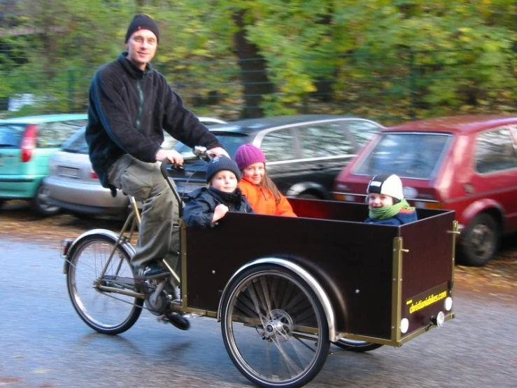 two boys and an adult riding a bike in the street