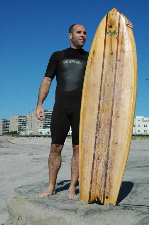 a man is standing on the beach holding a surf board