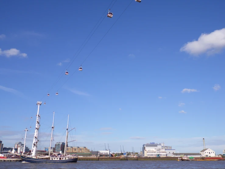 several people in a harbor flying kites over the water