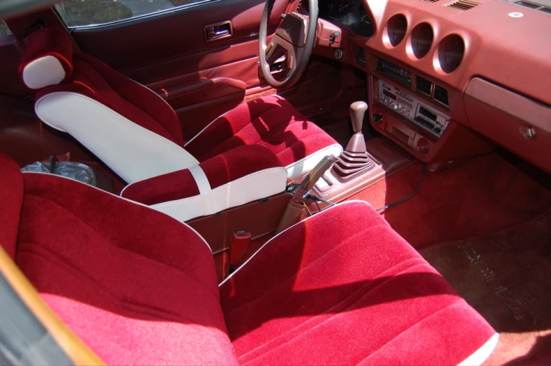 the interior of an old car with red velvet