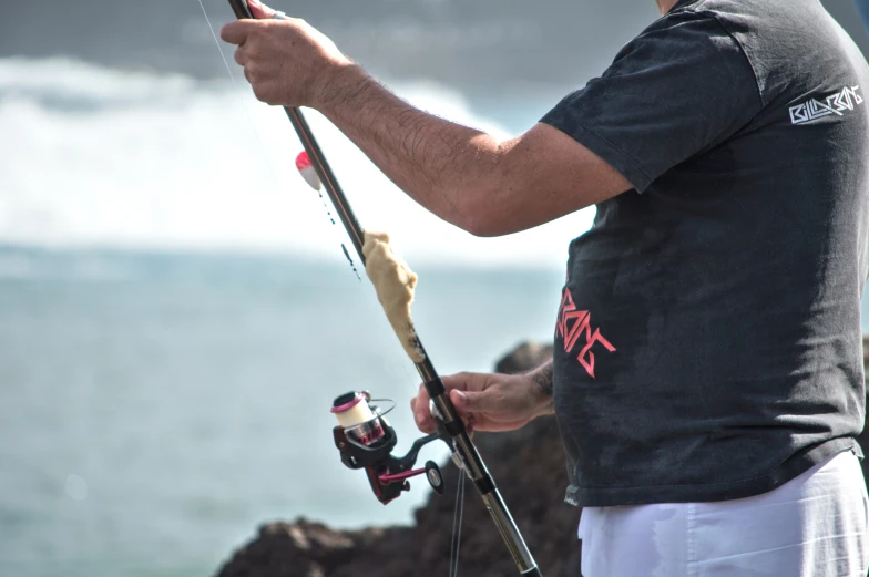 a man is fishing off the cliff side