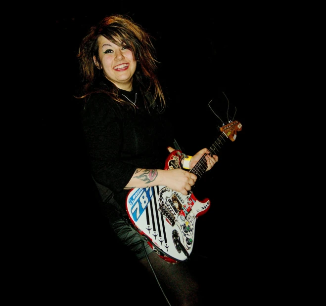 a woman with long hair holding a small guitar