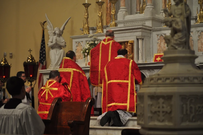 a couple of men dressed in red are standing next to another man