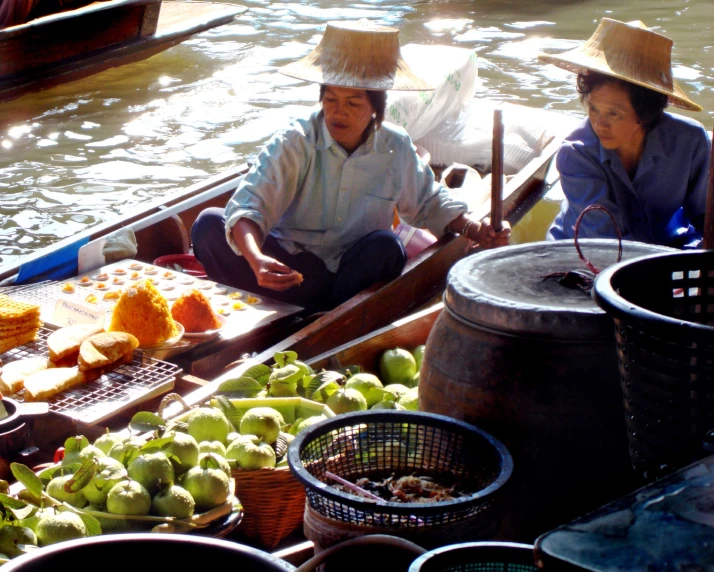 a man and woman on a boat selling vegetables