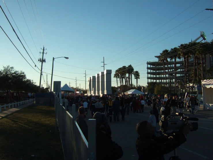 people crowding around in an urban area on a sunny day