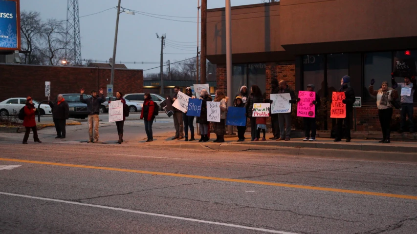 a group of protesters holding signs on the street