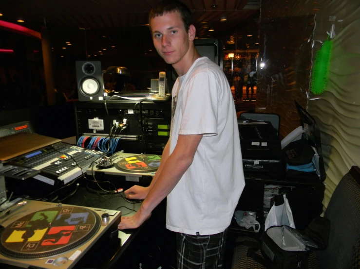 a young man at a sound mixing studio with several equipment