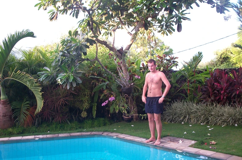 an image of man standing near a swimming pool