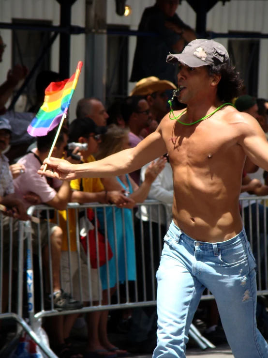 a man with  holds onto a rainbow flag