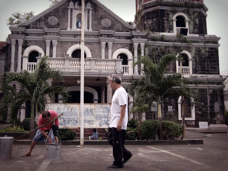 two men are working outside of a large building