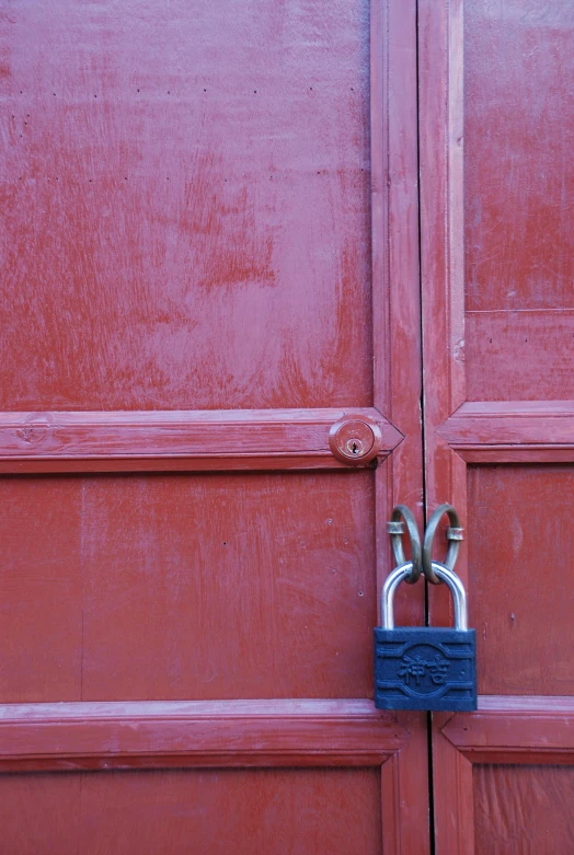 a close up of a lock on the side of a red door