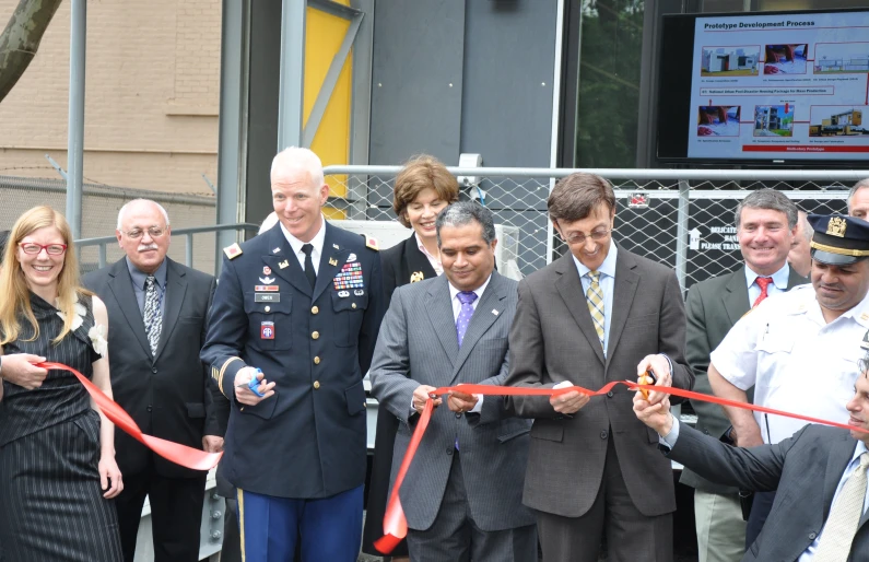 a man in military uniform cuts the ribbon to cut the ceremonial ribbon for a group of people