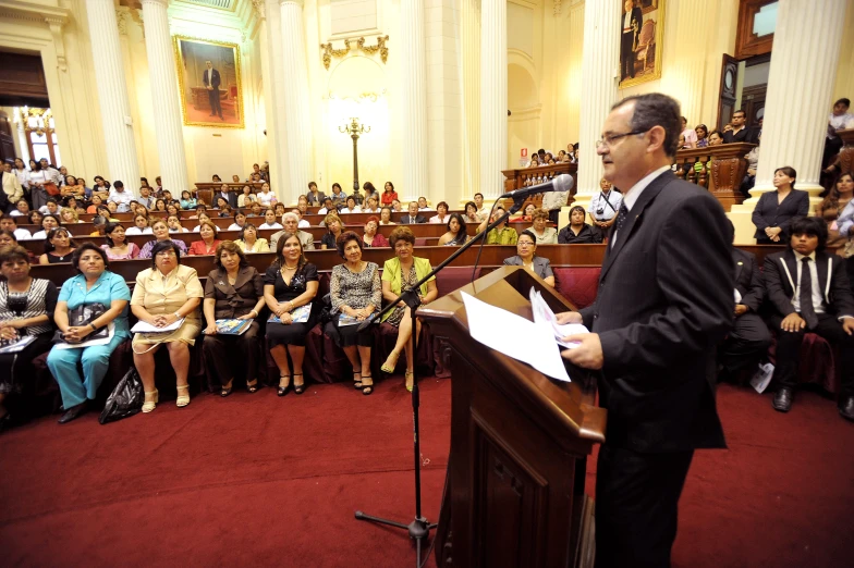 a man standing in front of a podium talking into a microphone