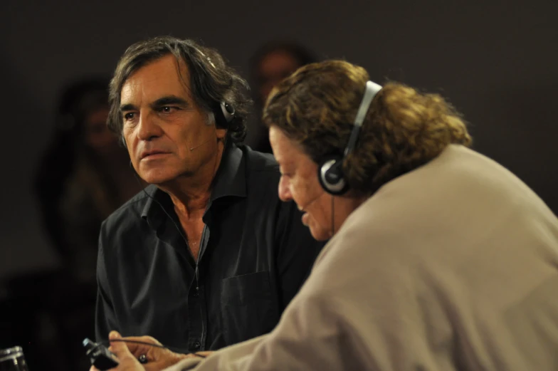 a woman sitting next to a man with head phones on