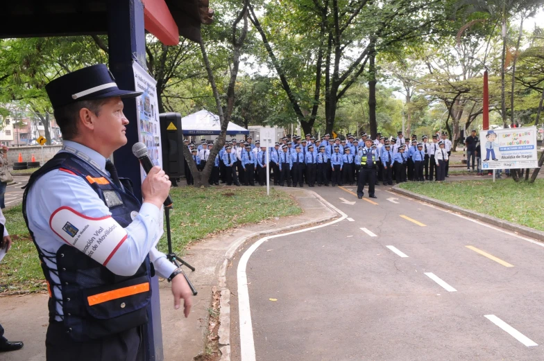 a policeman speaks into microphone to a crowd