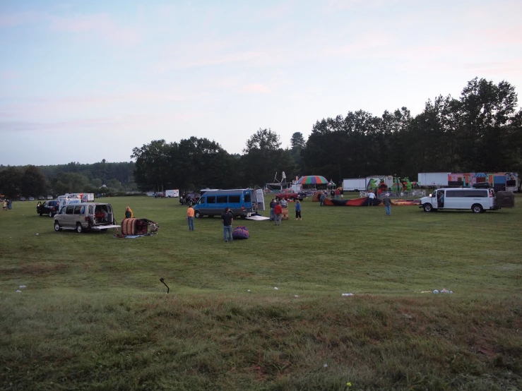 many old trucks sit near each other in a large field