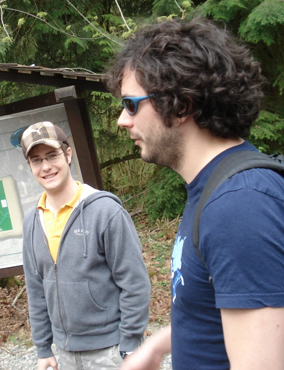 two men are standing near an information board