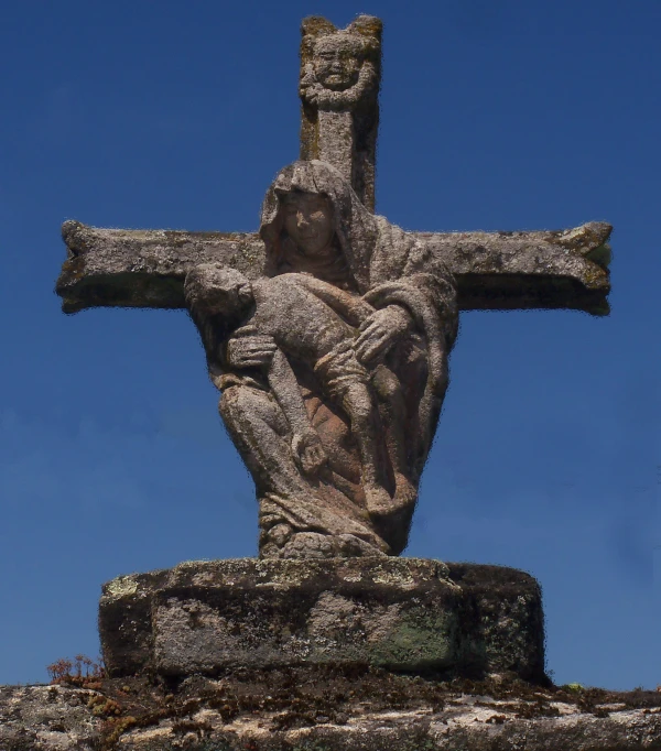 a cross on a stone with a blue sky behind it