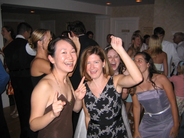 group of smiling women holding up one finger