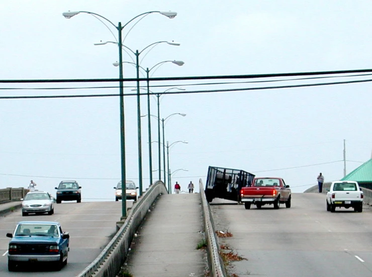 two vehicles are stopped on a highway as a car is driving past them