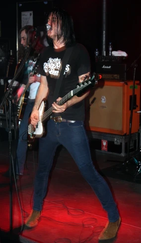 a man in black shirt playing guitar at night