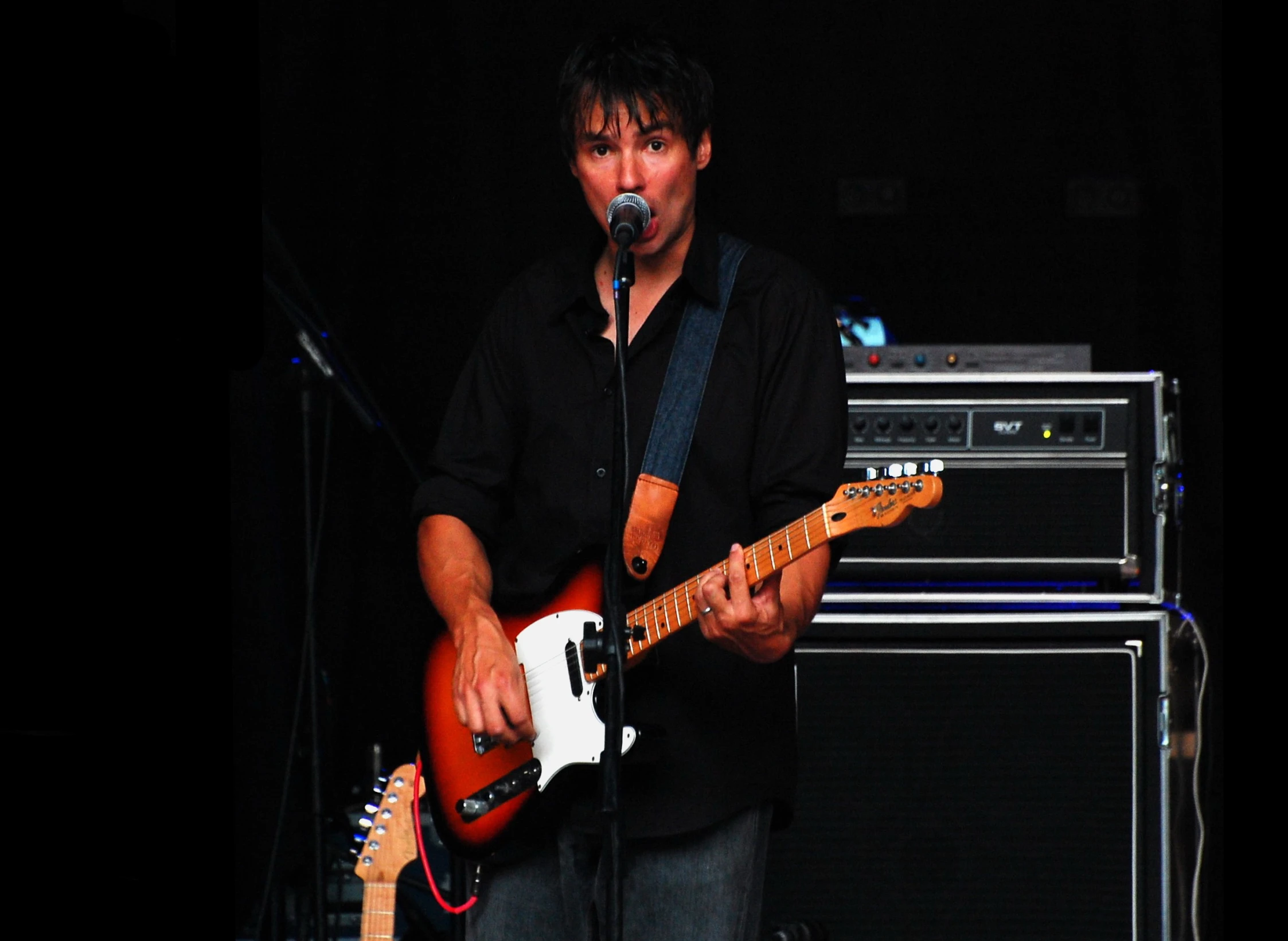 the musician is singing with his electric guitar