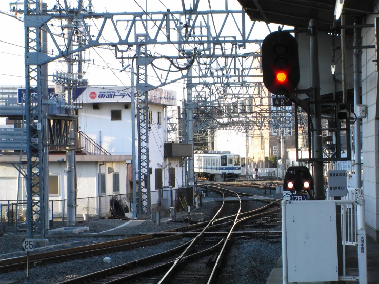 train track with the lights on in front of buildings