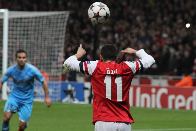 a soccer player prepares to head the ball as another player holds his arms in the air