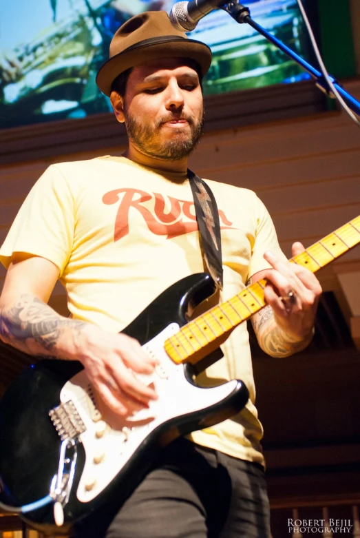 a man is holding a guitar playing the music