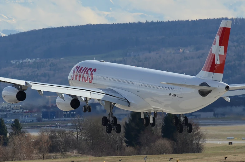 a swiss passenger jet taking off from an airport runway