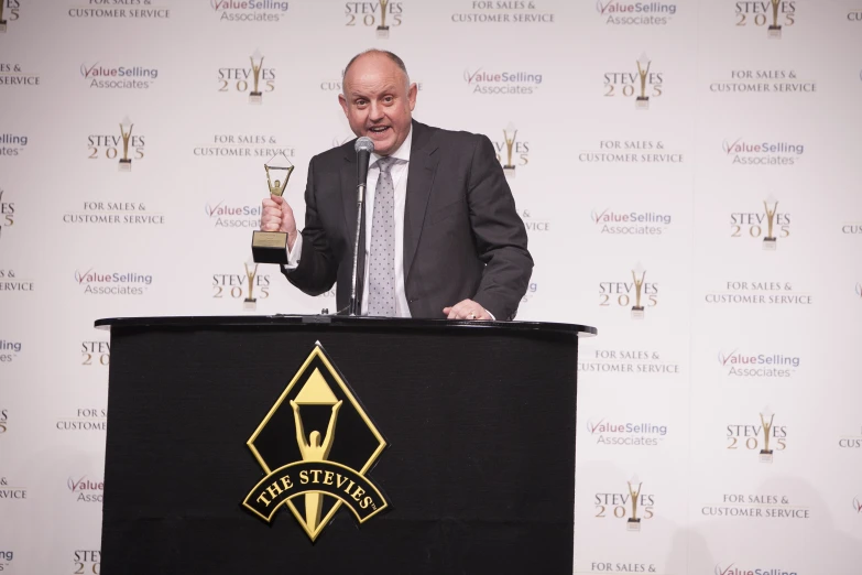 a man at a podium holding an award