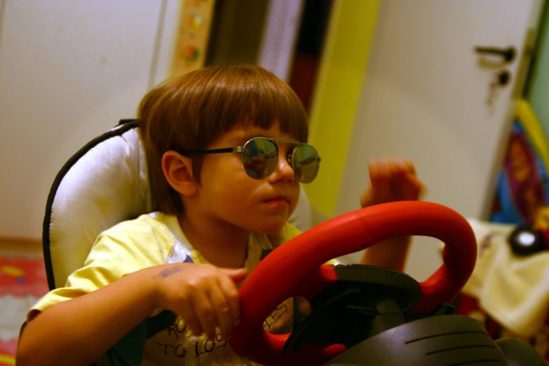 a small child sitting in a baby chair holding a steering wheel